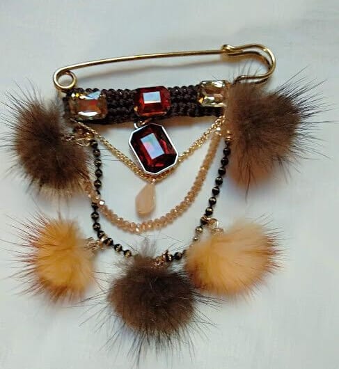 Broche alfiler dorado con piedras y pompones vison marrones.Nuevo