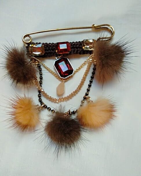 Broche alfiler dorado con piedras y pompones vison marrones.Nuevo