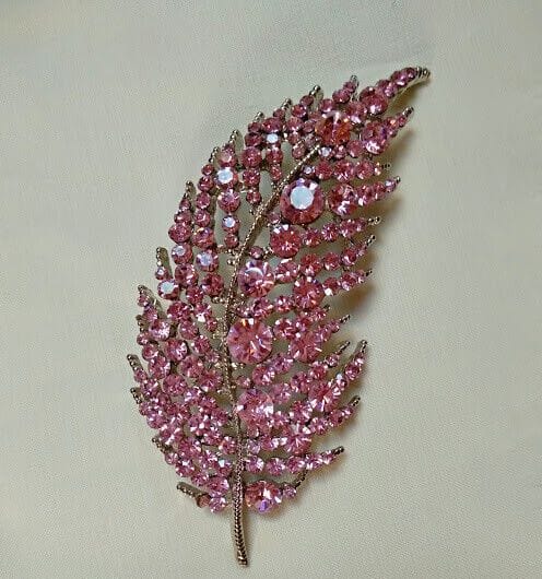 Broche bisuteria plateado en forma de hoja cuajado de piedras color rosa.Nuevo