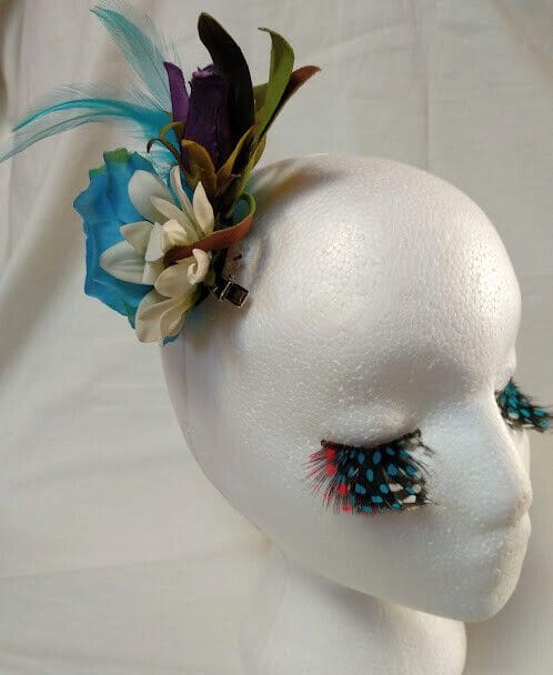 Tocado broche mujer combinado flores y plumas tonos azules y morados.