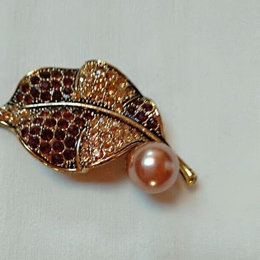 Broche bisuteria en forma de hoja cuajado de piedras en tonos marrones .Nuevo