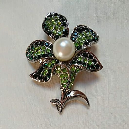 Broche bisuteria plateado en forma de flor cuajado piedras verdes y perla .Nuevo