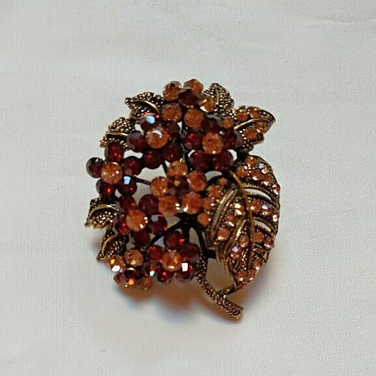 Broche bisuteria tipo vintage  con piedras tonos marrones.Nuevo