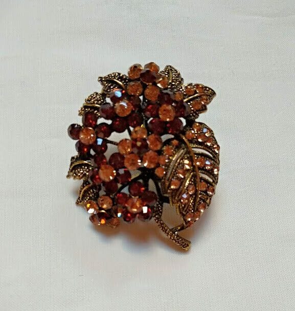 Broche bisuteria tipo vintage  con piedras tonos marrones.Nuevo