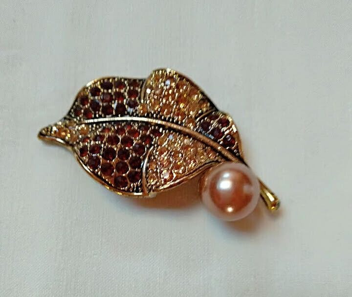 Broche bisuteria en forma de hoja cuajado de piedras en tonos marrones .Nuevo